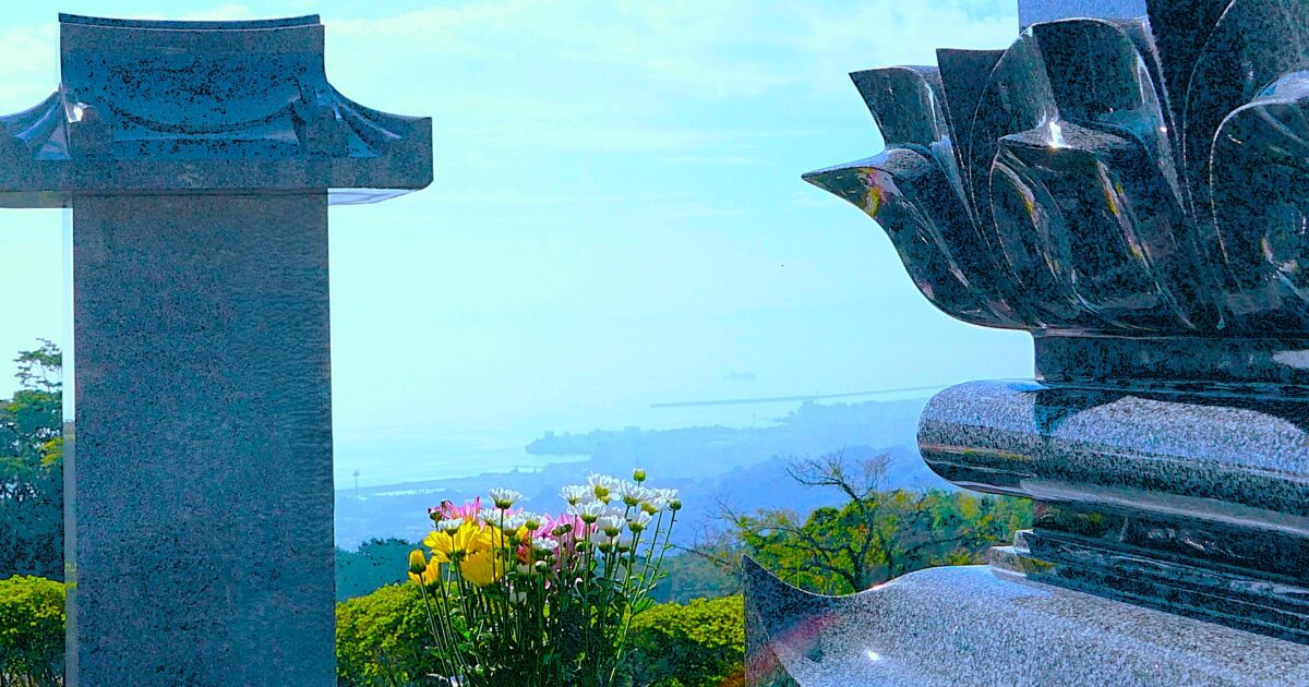 高台の墓地と墓石と供花の風景