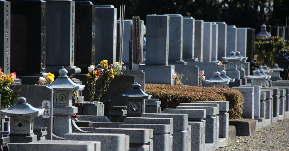 日本の墓地に並ぶ墓石と石灯籠
