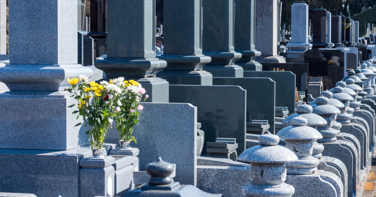 日本の墓地に並ぶ墓石と供花