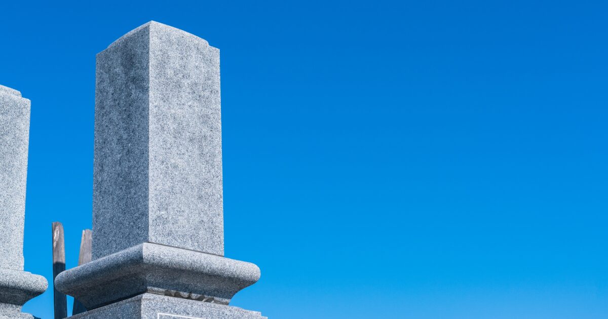 青空を背景にした日本の墓石