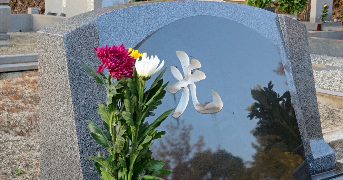 花と刻字がある日本の墓石