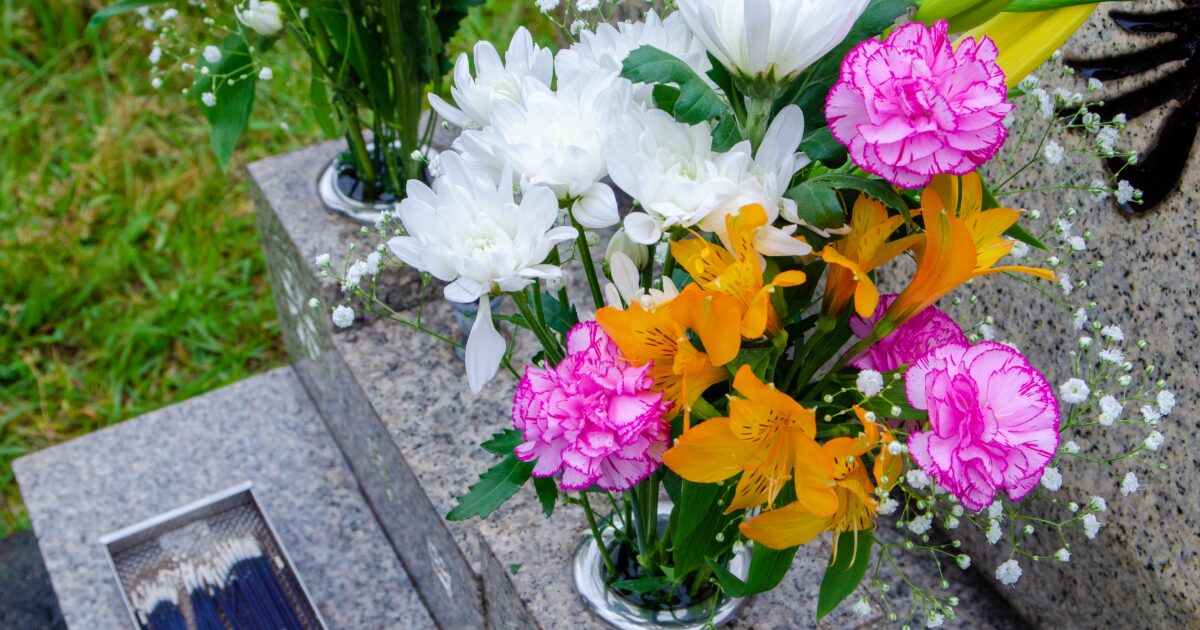 墓前に供えられた菊とカーネーションの花
